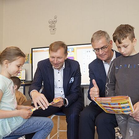 Burgemeester Gert-Jan Kats en wethouder Marco0 Verloop kijken mee met Oekraïense kinderen in taalschool Pimpelmees. 